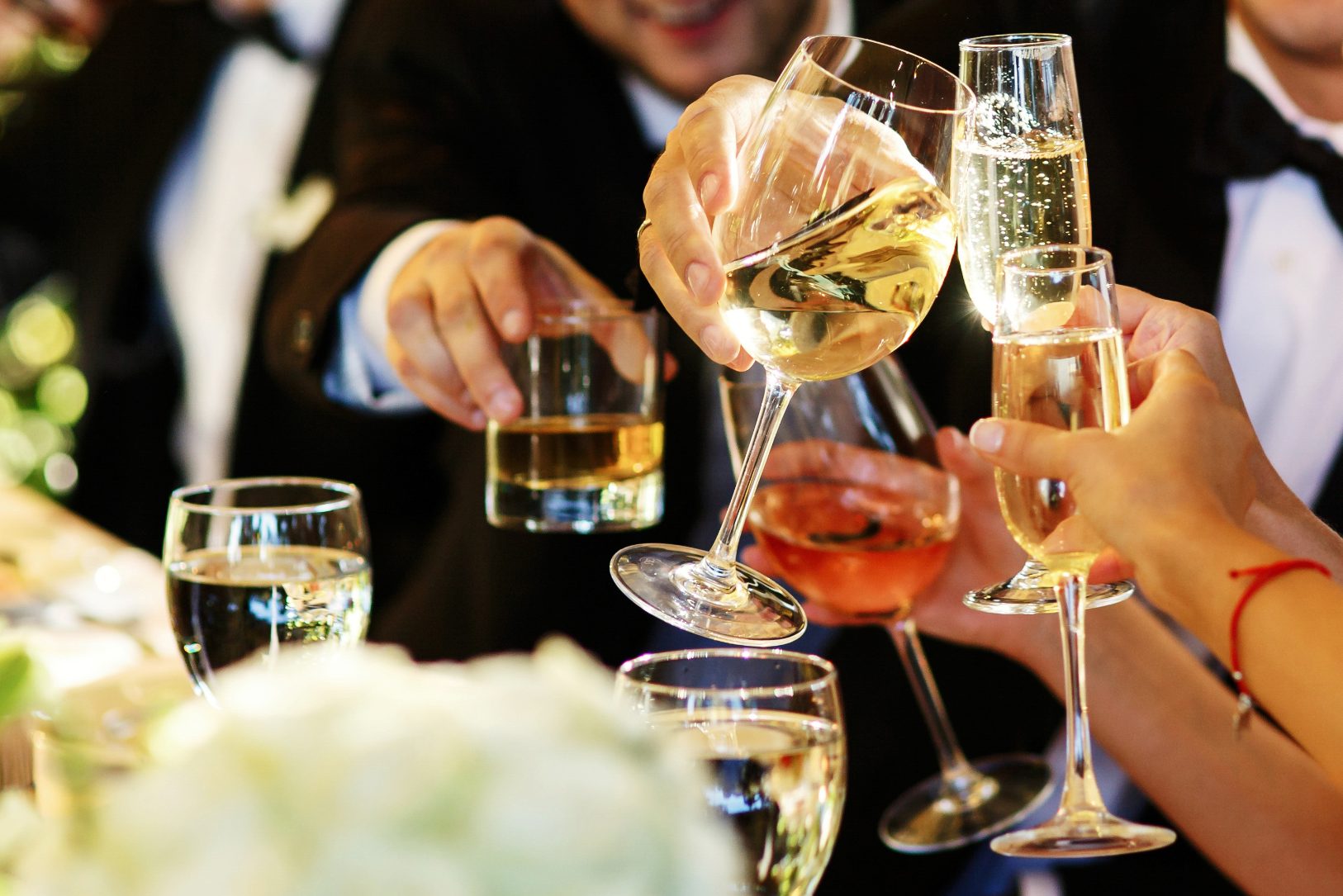 A group of wedding guests toasting with glasses of wine